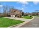 Beautiful brick home featuring a spacious driveway, well-manicured lawn, and a three-car garage at 409 Conaway Ct, Waxhaw, NC 28173