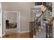 A carpeted staircase features an elegant wood and iron handrail, neutral paint, and access to a room at 409 Conaway Ct, Waxhaw, NC 28173