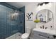 Stylish bathroom featuring blue tile, a glass shower, and a contemporary round mirror at 4308 Welling Ave, Charlotte, NC 28208