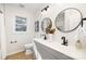 Modern bathroom with dual sinks, round mirrors, black hardware and updated fixtures at 4308 Welling Ave, Charlotte, NC 28208