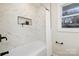 Modern bathroom showcasing a sleek bathtub with black hardware and a built-in marble tiled shelving niche at 4308 Welling Ave, Charlotte, NC 28208