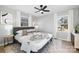 Bright bedroom featuring a ceiling fan, two windows, and a bed with decorative pillows and a patterned throw at 4308 Welling Ave, Charlotte, NC 28208