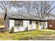 Quaint home featuring a white brick exterior and a walkway leading to the green front door at 4308 Welling Ave, Charlotte, NC 28208