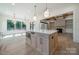 Bright kitchen featuring a quartz countertop island, modern lighting, and an open floor plan to the living area at 4311 Collingwood Dr, Charlotte, NC 28209