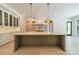 Kitchen with large island featuring a stone countertop, pendant lights, and custom cabinets at 4311 Collingwood Dr, Charlotte, NC 28209