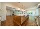 Spacious kitchen island with white countertops, wooden cabinetry, and pendant lighting at 4311 Collingwood Dr, Charlotte, NC 28209