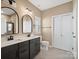 Bathroom featuring double vanity sinks, a commode, and stylish fixtures at 6420 Cambridge Dr, Harrisburg, NC 28075