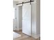 Modern white sliding barn door with black hardware and light wood floors at 813 Carrid Dr, Gastonia, NC 28052