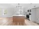 Kitchen with white cabinetry, stainless appliances, a kitchen island, tile backsplash, and modern lighting at 813 Carrid Dr, Gastonia, NC 28052