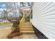 Inviting entryway featuring wooden stairs and railing leading to a covered porch and freshly painted siding at 813 Carrid Dr, Gastonia, NC 28052