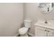 Clean powder room featuring a white vanity, toilet, and round mirror at 9562 Littleleaf Dr, Charlotte, NC 28215