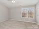 Spacious bedroom with neutral walls and carpet, offering a calming space at 9562 Littleleaf Dr, Charlotte, NC 28215