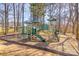 Community playground featuring a green playset with slides and climbing structures in a natural, wooded setting at 9562 Littleleaf Dr, Charlotte, NC 28215