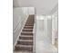 Inviting hallway with stairs leading to upper levels, featuring neutral tones and ample lighting at 10094 Treeside Ln, Matthews, NC 28105