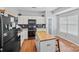 Modern kitchen featuring white cabinetry, black backsplash, and stainless steel appliances at 10094 Treeside Ln, Matthews, NC 28105