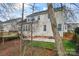 Exterior view of the home with a large deck, walk-out patio, and partially wooded yard at 1017 Anduin Falls Dr, Charlotte, NC 28269