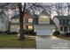 Charming two-story home with a two-car garage, manicured lawn, and mature trees at 1017 Anduin Falls Dr, Charlotte, NC 28269