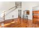 Open-concept living area featuring a staircase, kitchen view, and hardwood flooring at 1017 Anduin Falls Dr, Charlotte, NC 28269