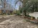 Spacious backyard featuring a vintage patio set, mature trees, and ample room for outdoor activities at 1030 Bolling Rd, Charlotte, NC 28207