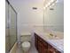 Bathroom featuring a glass enclosed shower, white tile, vanity, toilet, and large mirror at 1030 Bolling Rd, Charlotte, NC 28207