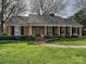 Charming brick home with a well-manicured lawn and covered front porch at 1030 Bolling Rd, Charlotte, NC 28207