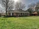 Charming brick home with a well-maintained lawn, classic columns, and neat landscaping at 1030 Bolling Rd, Charlotte, NC 28207