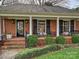 Inviting front porch with brick flooring, seating, and classic columns at 1030 Bolling Rd, Charlotte, NC 28207