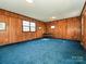 Large room with wood paneled walls and blue carpet at 1030 Bolling Rd, Charlotte, NC 28207