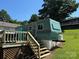 A blue and white mobile home is landscaped on a grassy lot with a small deck at 104 Trestle Cir, New London, NC 28127