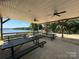 Covered picnic area with tables and ceiling fans overlooking the lake at 104 Trestle Cir, New London, NC 28127