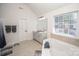 Bright bathroom features a double vanity, soaking tub, and neutral tile flooring at 10836 Clark St, Davidson, NC 28036