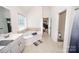 Well-lit bathroom showcasing a corner tub, neutral tile, and a double vanity at 10836 Clark St, Davidson, NC 28036