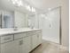 Elegant bathroom featuring double sinks, a large vanity, modern lighting, and a glass-enclosed shower at 109 Alluvium Ln, Waxhaw, NC 28173