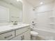 Modern bathroom featuring a vanity with white cabinets and tub with white tile surround at 109 Alluvium Ln, Waxhaw, NC 28173