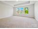 Primary bedroom featuring neutral carpet, a tray ceiling, recessed lighting, and several windows for natural light at 109 Alluvium Ln, Waxhaw, NC 28173