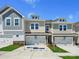 New construction townhomes boast craftsman exteriors, attached garages, and manicured lawns under a bright, sunny sky at 109 Alluvium Ln, Waxhaw, NC 28173