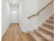 Bright hallway with wood-look flooring and staircase with carpeted treads and wood railing at 109 Alluvium Ln, Waxhaw, NC 28173