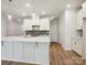 Modern kitchen with large island, quartz countertops, stainless steel appliances, and wood-look flooring at 109 Alluvium Ln, Waxhaw, NC 28173
