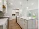 Open kitchen boasts large island, stainless appliances, wood-look flooring, and recessed lighting at 109 Alluvium Ln, Waxhaw, NC 28173
