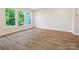 Bright living room featuring wood-look flooring, white walls, and large windows offering natural light at 109 Alluvium Ln, Waxhaw, NC 28173