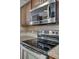 Close up of stainless steel stove and microwave, with granite countertops and tile backsplash at 11000 White Stag Dr, Charlotte, NC 28269