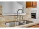 Close up of kitchen sink with granite countertops, tile backsplash, and a view of living room at 11000 White Stag Dr, Charlotte, NC 28269