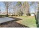 View of large backyard with an outbuilding, mature trees, and partial patio at 1107 Franklin Thomas Pl, Charlotte, NC 28214