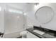 This full bathroom features a tub/shower combo, white cabinets, and a vanity with a black countertop at 1107 Franklin Thomas Pl, Charlotte, NC 28214