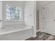 Bright bathroom with a soaking tub, shower, and large window offering plenty of natural light at 1107 Franklin Thomas Pl, Charlotte, NC 28214