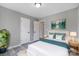 Comfortable bedroom with a white bed, teal accents, and neutral gray walls at 1107 Franklin Thomas Pl, Charlotte, NC 28214