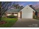 Charming single-story brick home featuring an attached two-car garage and manicured front lawn at 1107 Franklin Thomas Pl, Charlotte, NC 28214