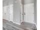 Hallway with gray wood-look flooring, neutral walls, and multiple white doors at 1107 Franklin Thomas Pl, Charlotte, NC 28214