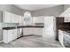 Well-lit kitchen with white cabinets, black countertops, stainless steel appliances, and modern flooring at 1107 Franklin Thomas Pl, Charlotte, NC 28214