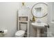 Cozy bathroom with pedestal sink and toilet with storage cabinet and round mirror at 112 Abersham Dr, Mooresville, NC 28115